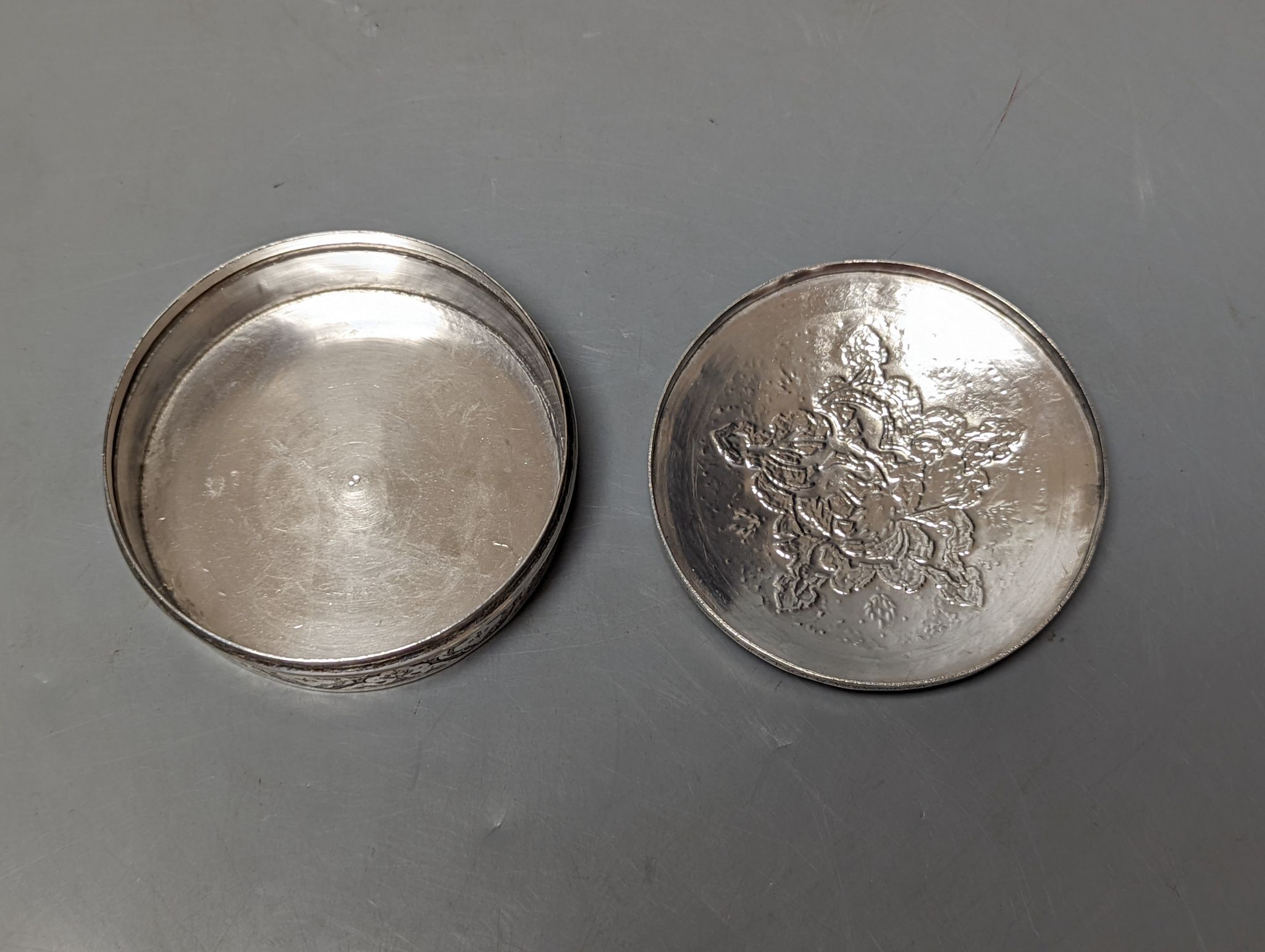 A Persian engraved white metal circular box and cover, 86mm